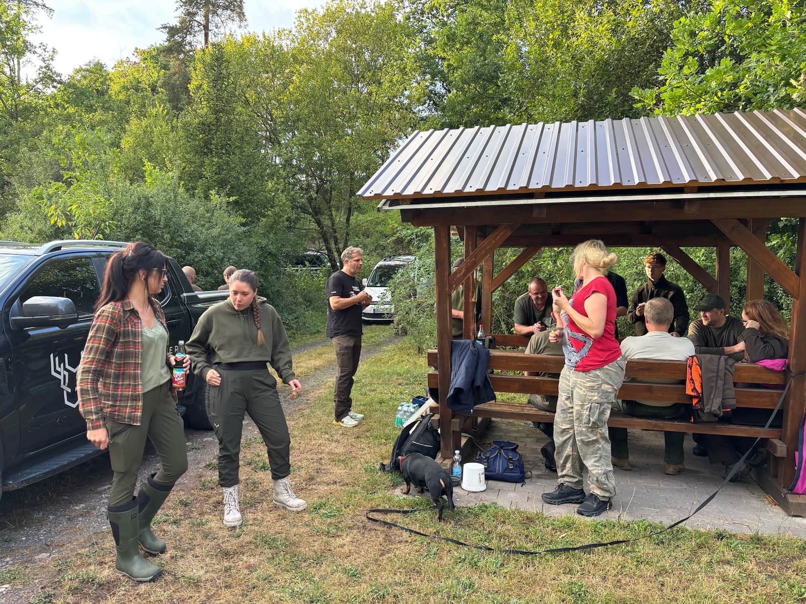 Kursgruppe draußen an einer Hütte im Wald